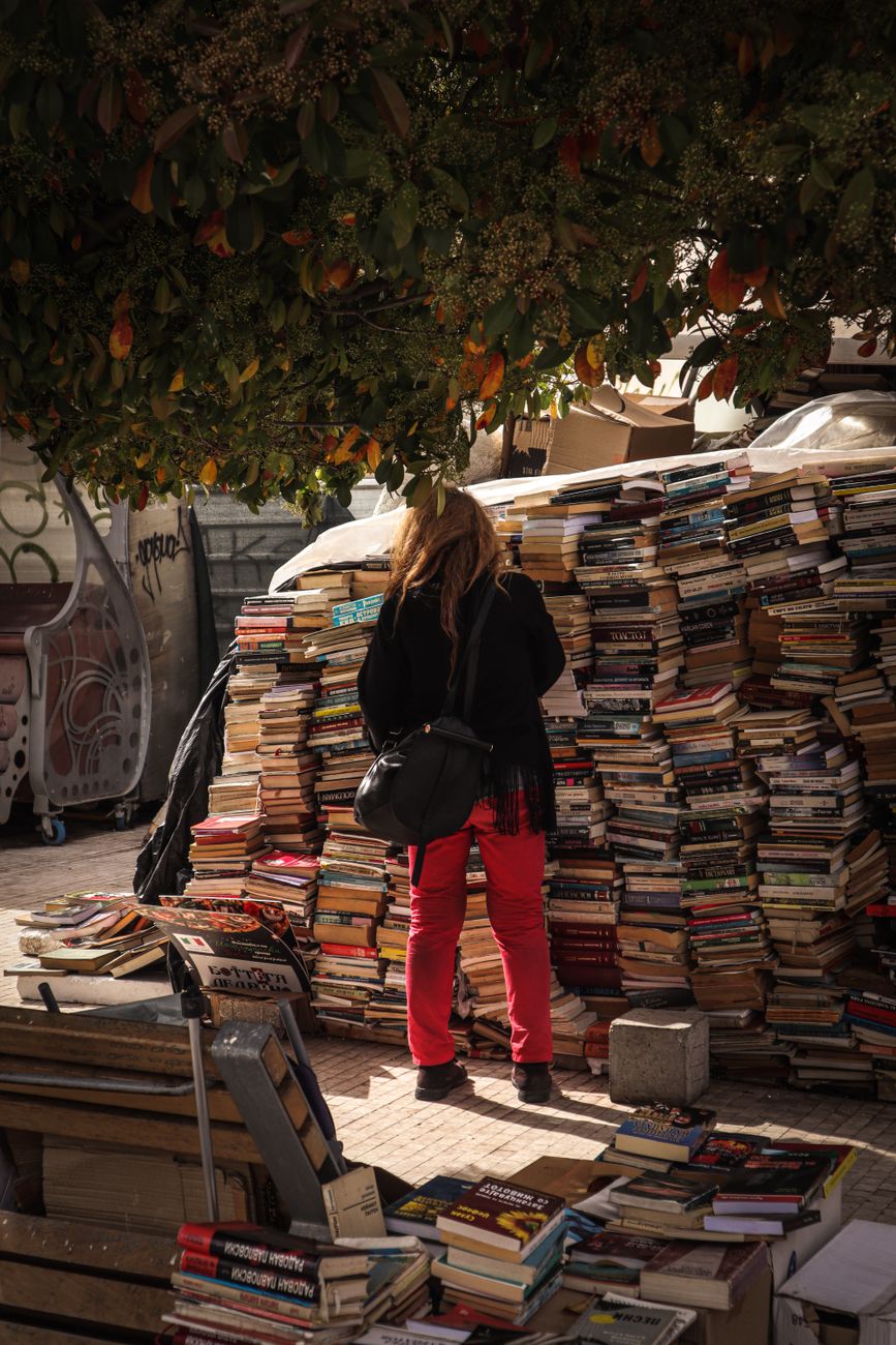 a person looking at a pile of books